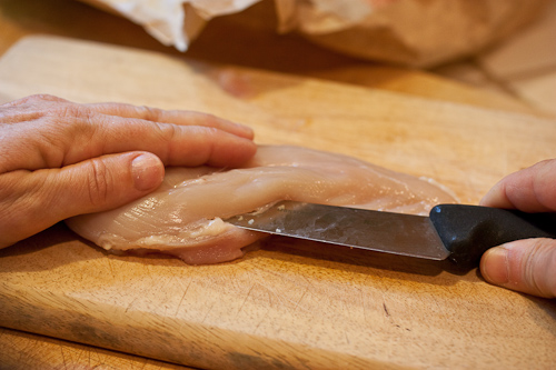 Sweep the knife up toward the top of the breast, cutting parallel to the board but without cutting through the other side